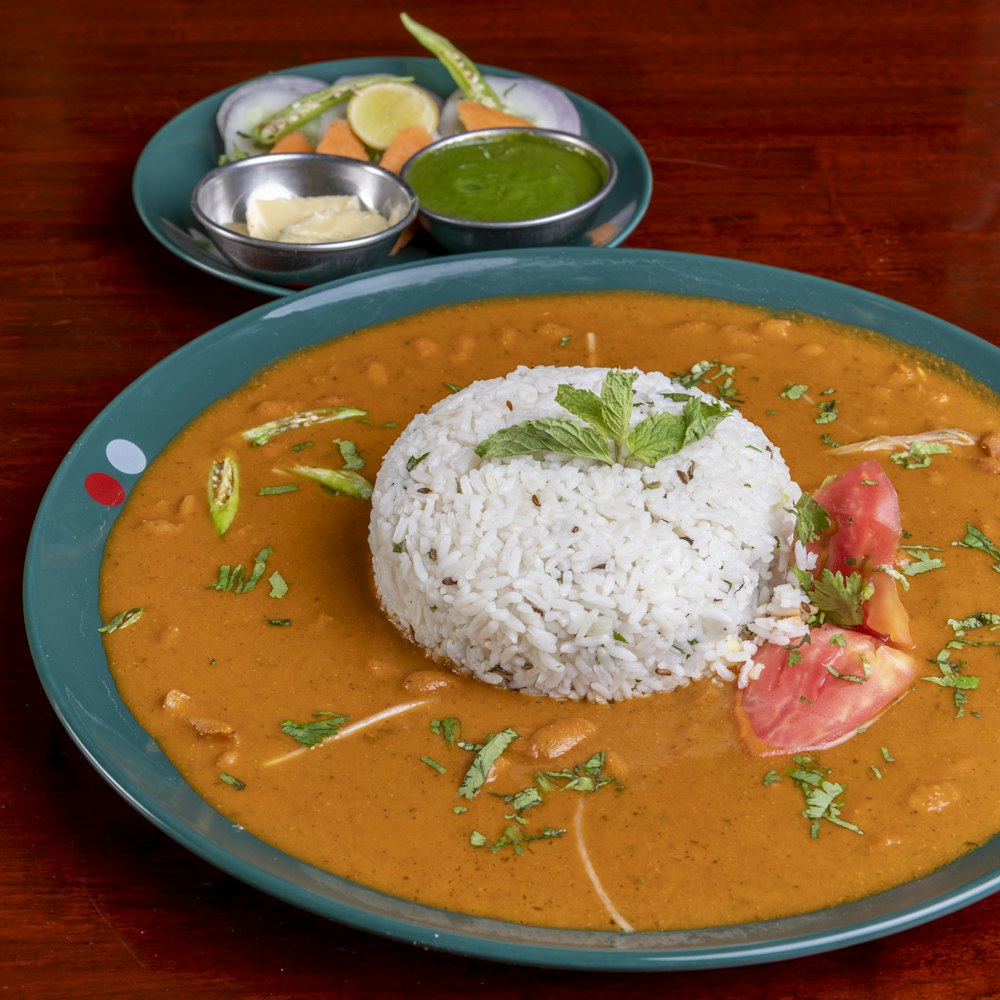 A plate of daal chaawal: a mound of steamed basmati rice ringed with daal, finished with fresh mint and coriander